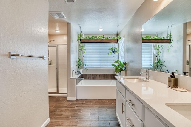 212 Arbor Dr S, Madera, CA 93636 - full bath with a textured wall, a bath, a shower stall, double vanity, and wood finish floors