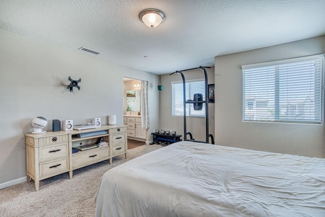 212 Arbor Dr S, Madera, CA 93636 - bedroom with light colored carpet, a textured ceiling, and connected bathroom