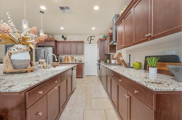 3982 Flint Ave, Clovis, CA 93619 - kitchen with stainless steel appliances, tasteful backsplash, light stone counters, a center island with sink, and hanging light fixtures