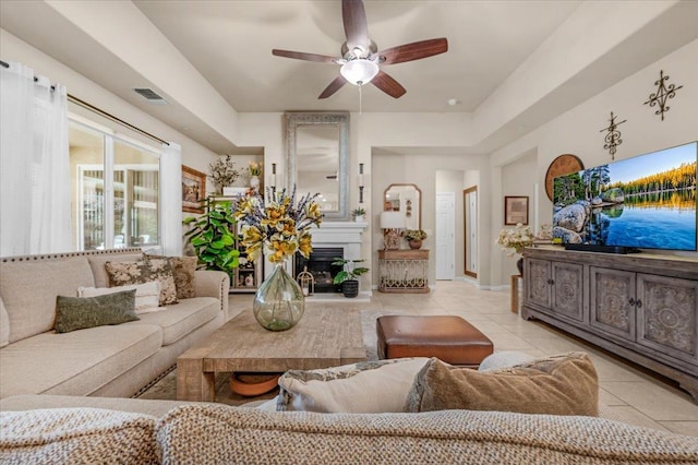 3982 Flint Ave, Clovis, CA 93619 - living area featuring light tile patterned floors, a ceiling fan, and a glass covered fireplace
