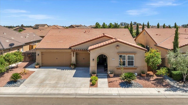 3982 Flint Ave, Clovis, CA 93619 - mediterranean / spanish-style house featuring an attached garage, a tiled roof, stucco siding, and driveway