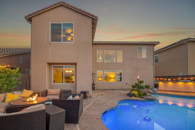 4367 Salem Ln, Clovis, CA 93619 - back of house at dusk featuring an outdoor living space with a fire pit, stucco siding, a patio area, and a tiled roof