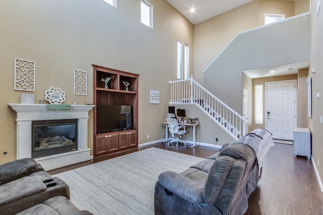 7230 E Dayton Ave, Fresno, CA 93737 - living area featuring a towering ceiling, stairs, dark wood finished floors, a glass covered fireplace, and recessed lighting