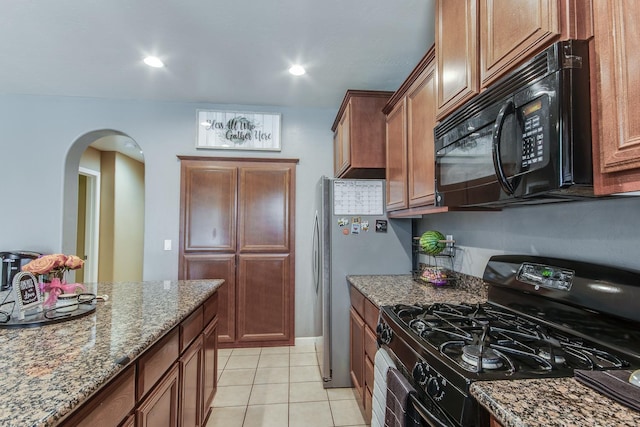 7230 E Dayton Ave, Fresno, CA 93737 - kitchen with black appliances, arched walkways, stone counters, light tile patterned flooring, and brown cabinetry