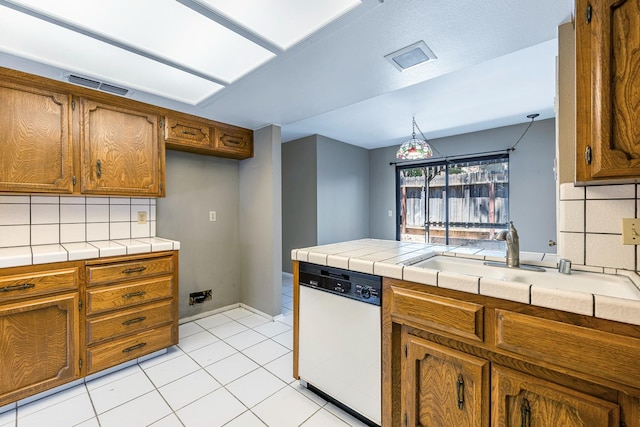 2076 W Calimyrna Ave Unit 102, Fresno, CA 93711 - kitchen with white dishwasher, brown cabinets, backsplash, tile countertops, and light tile patterned floors