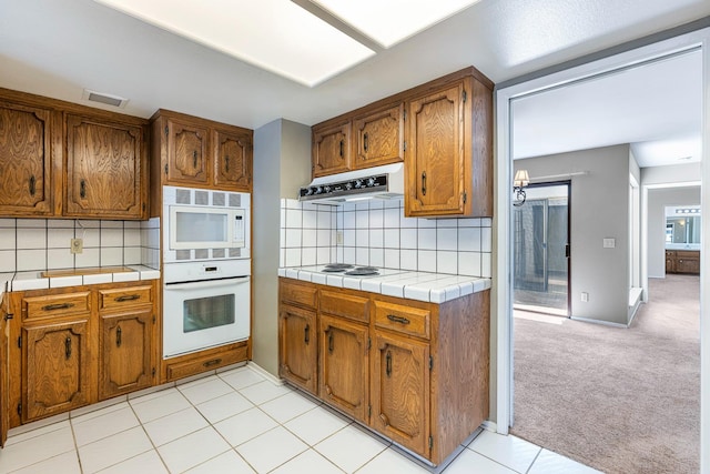 2076 W Calimyrna Ave Unit 102, Fresno, CA 93711 - kitchen featuring white appliances, under cabinet range hood, and brown cabinets