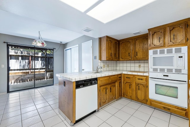 2076 W Calimyrna Ave Unit 102, Fresno, CA 93711 - kitchen featuring white appliances, brown cabinets, and tile counters
