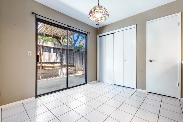 2076 W Calimyrna Ave Unit 102, Fresno, CA 93711 - unfurnished bedroom featuring access to exterior, a closet, and light tile patterned floors