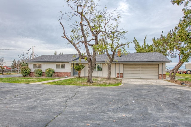 11016 E S Ave, Selma, CA 93662 - view of front of home featuring asphalt driveway, an attached garage, brick siding, a front lawn, and stucco siding