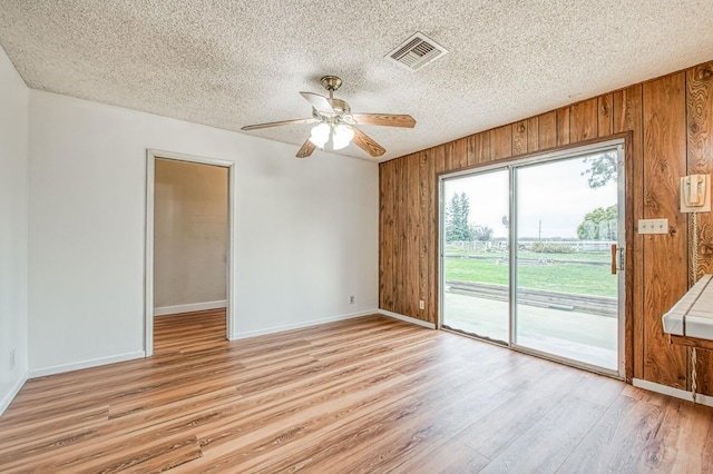 11016 E S Ave, Selma, CA 93662 - spare room with wooden walls, light wood finished floors, a ceiling fan, and a textured ceiling