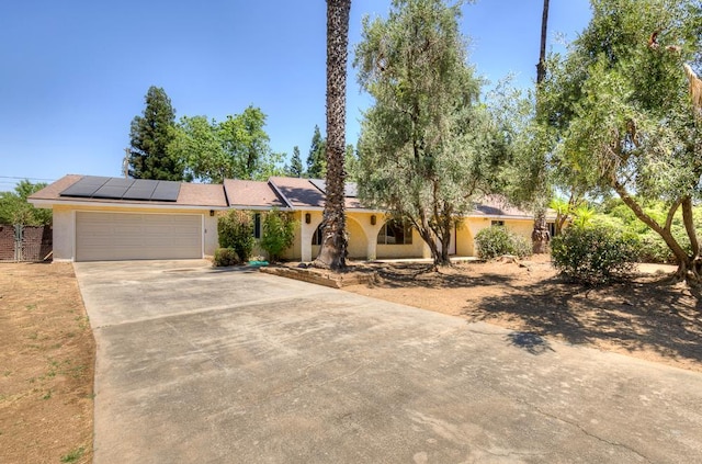 41151 Fig Grove Cir, Madera, CA 93636 - view of front of property featuring concrete driveway, stucco siding, a garage, and solar panels