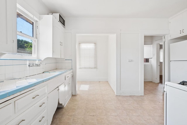 3334 E Montecito Ave, Fresno, CA 93702 - kitchen with tile countertops, white appliances, decorative backsplash, white cabinets, and light floors