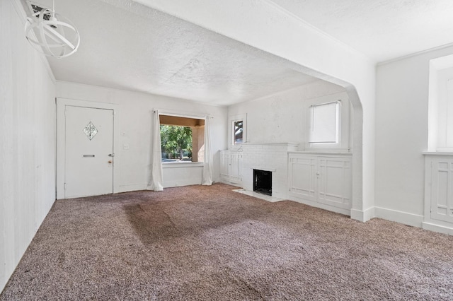 3334 E Montecito Ave, Fresno, CA 93702 - unfurnished living room with carpet, a brick fireplace, a textured ceiling, and arched walkways