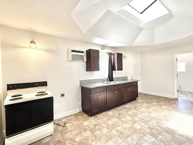 3334 E Montecito Ave, Fresno, CA 93702 - kitchen featuring electric stove, a wall unit AC, a skylight, light countertops, and healthy amount of natural light