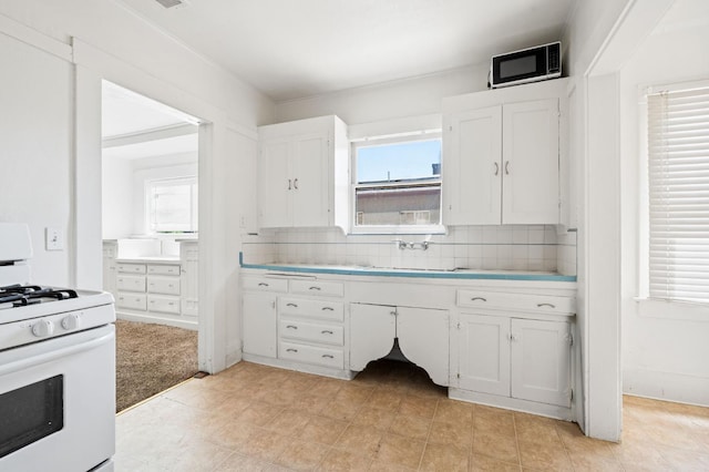 3334 E Montecito Ave, Fresno, CA 93702 - kitchen featuring gas range gas stove, white cabinetry, tasteful backsplash, and plenty of natural light
