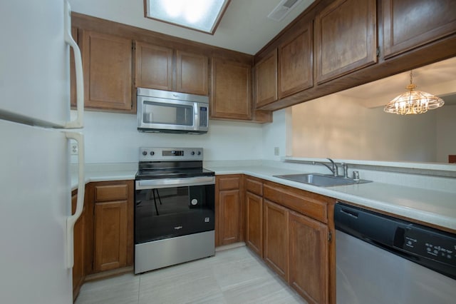 4875 N Backer Ave Unit 160, Fresno, CA 93726 - kitchen with stainless steel appliances, light countertops, brown cabinets, and a chandelier