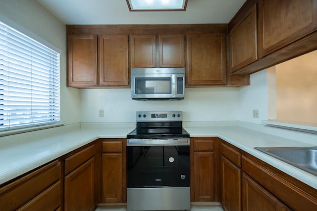 4875 N Backer Ave Unit 160, Fresno, CA 93726 - kitchen with appliances with stainless steel finishes, plenty of natural light, light countertops, and brown cabinets