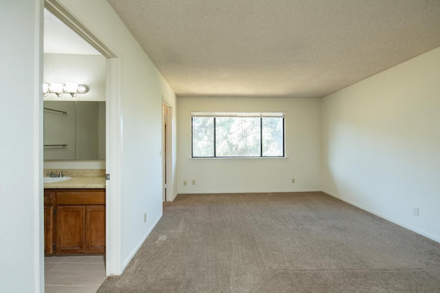 4875 N Backer Ave Unit 160, Fresno, CA 93726 - unfurnished bedroom featuring light carpet, connected bathroom, and a textured ceiling