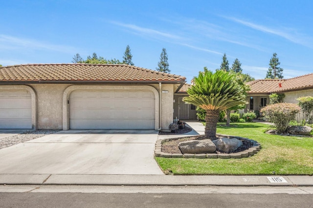 115 Prince Ln, Madera, CA 93637 - mediterranean / spanish home featuring concrete driveway, a front lawn, stucco siding, a tile roof, and a garage