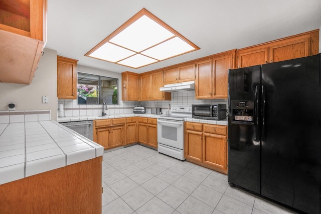 115 Prince Ln, Madera, CA 93637 - kitchen with black fridge with ice dispenser, white electric range oven, tile counters, dishwasher, and under cabinet range hood