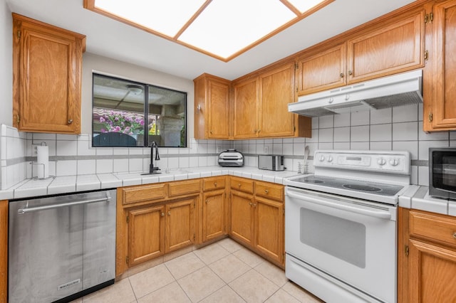 115 Prince Ln, Madera, CA 93637 - kitchen with dishwasher, white range with electric cooktop, under cabinet range hood, and decorative backsplash