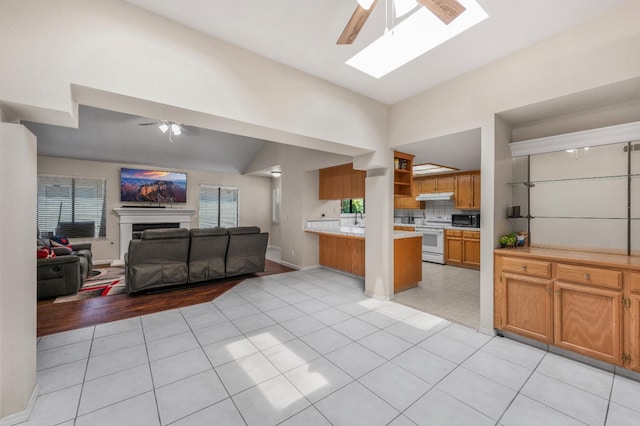 115 Prince Ln, Madera, CA 93637 - kitchen featuring white range with electric stovetop, ceiling fan, open floor plan, light countertops, and under cabinet range hood