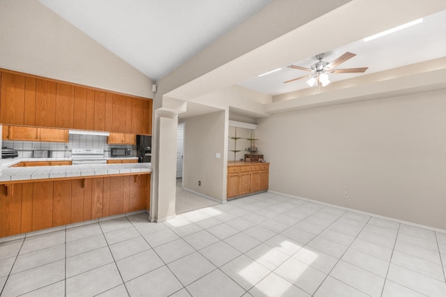 115 Prince Ln, Madera, CA 93637 - kitchen with tile counters, white range with electric cooktop, brown cabinetry, a ceiling fan, and decorative backsplash