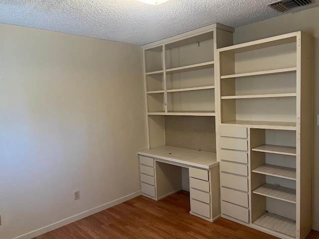 6924 N Winery, Fresno, CA 93710 - unfurnished office with dark wood finished floors, built in desk, and a textured ceiling