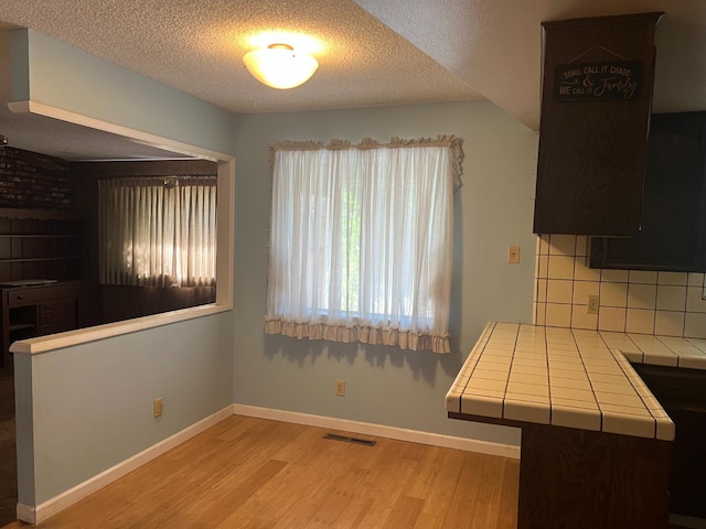 6924 N Winery, Fresno, CA 93710 - unfurnished dining area featuring wood finished floors and a textured ceiling