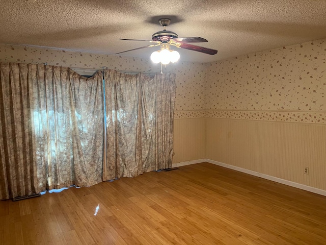 6924 N Winery, Fresno, CA 93710 - spare room featuring a wainscoted wall, wood finished floors, ceiling fan, a textured ceiling, and wallpapered walls