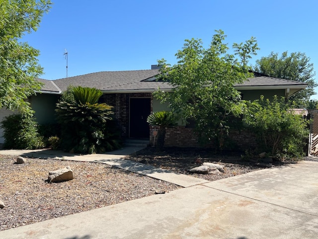 6924 N Winery, Fresno, CA 93710 - view of property hidden behind natural elements featuring brick siding and roof with shingles