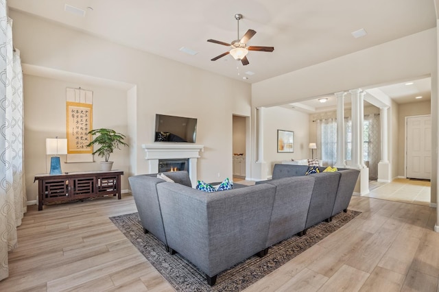 10911 E Swift Ave, Clovis, CA 93619 - living area with decorative columns, light wood finished floors, a ceiling fan, a glass covered fireplace, and recessed lighting