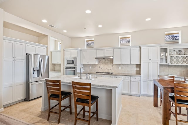 10911 E Swift Ave, Clovis, CA 93619 - kitchen with stainless steel appliances, backsplash, white cabinetry, a kitchen island with sink, and recessed lighting
