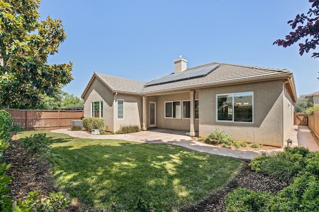 10911 E Swift Ave, Clovis, CA 93619 - rear view of property with stucco siding, a fenced backyard, roof mounted solar panels, a patio area, and a chimney