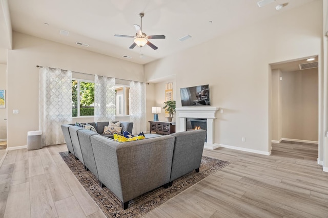 10911 E Swift Ave, Clovis, CA 93619 - living area featuring light wood-type flooring, a ceiling fan, and a glass covered fireplace