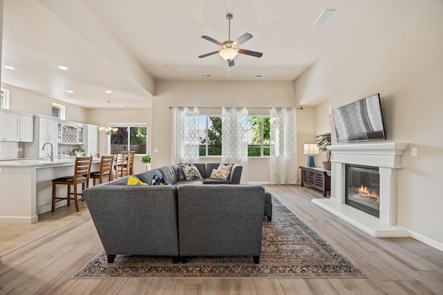 10911 E Swift Ave, Clovis, CA 93619 - living area with ceiling fan, a glass covered fireplace, light wood-style flooring, a chandelier, and recessed lighting