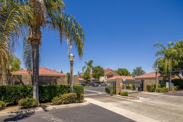 1542 E Alluvial Ave Unit 128, Fresno, CA 93720 - view of asphalt street featuring street lights, curbs, a gate, and a gated entry