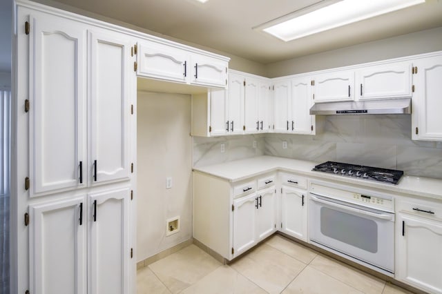 1542 E Alluvial Ave Unit 128, Fresno, CA 93720 - kitchen featuring white oven, under cabinet range hood, stainless steel gas cooktop, tasteful backsplash, and white cabinetry