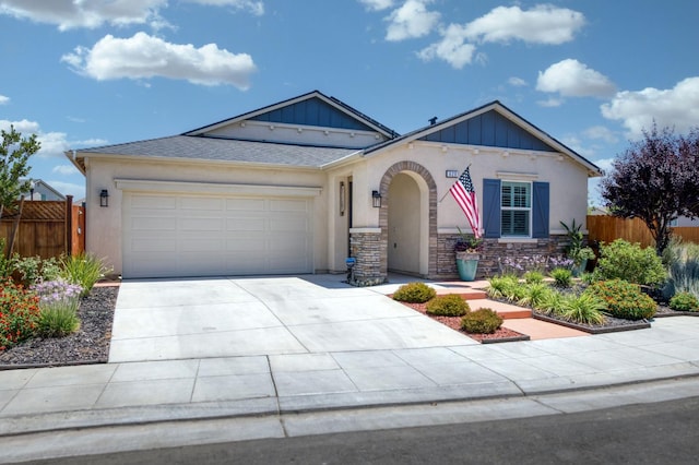 629 Del Monte Ave, Clovis, CA 93619 - view of front of home featuring an attached garage, driveway, board and batten siding, stone siding, and stucco siding
