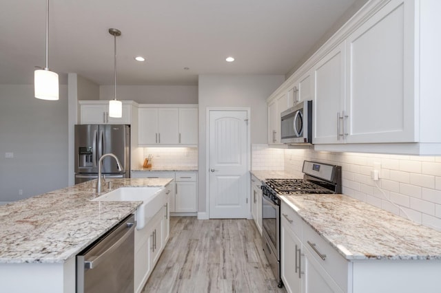 629 Del Monte Ave, Clovis, CA 93619 - kitchen featuring stainless steel appliances, white cabinets, decorative backsplash, light wood finished floors, and recessed lighting
