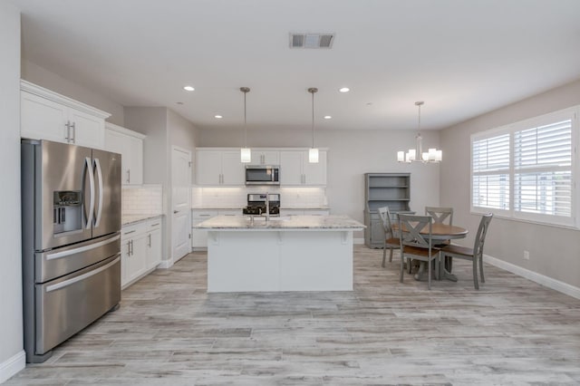 629 Del Monte Ave, Clovis, CA 93619 - kitchen featuring stainless steel appliances, recessed lighting, tasteful backsplash, white cabinets, and light wood-type flooring