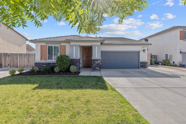 1066 Jade Way, Lemoore, CA 93245 - view of front facade with stucco siding, a garage, concrete driveway, and stone siding