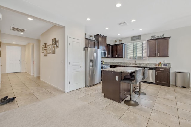 1066 Jade Way, Lemoore, CA 93245 - kitchen featuring stainless steel appliances, light tile patterned floors, a breakfast bar, and recessed lighting