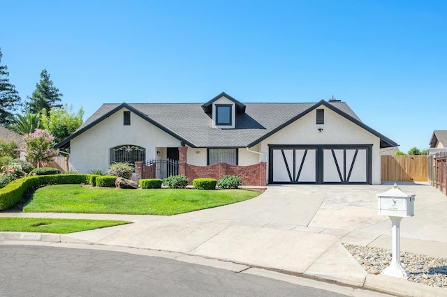 8501 N Akron Ave, Fresno, CA 93720 - tudor house with concrete driveway, a garage, brick siding, a shingled roof, and stucco siding