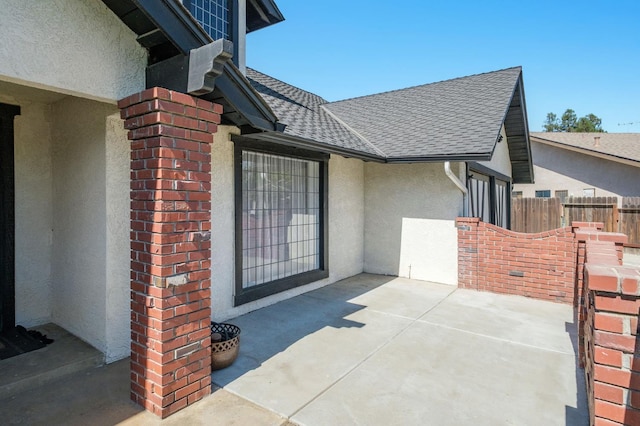 8501 N Akron Ave, Fresno, CA 93720 - property entrance featuring stucco siding, roof with shingles, and a patio area
