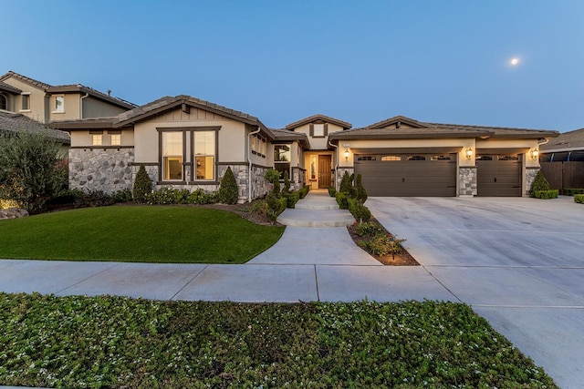 400 Ridge Creek Estates Way, Dinuba, CA 93618 - view of front of property with stone siding, stucco siding, concrete driveway, an attached garage, and a front lawn