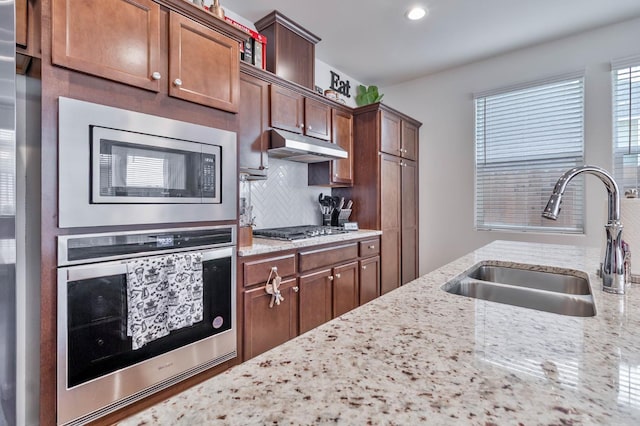 915 Winchell Way W, Madera, CA 93636 - kitchen featuring stainless steel appliances, under cabinet range hood, backsplash, light stone countertops, and recessed lighting