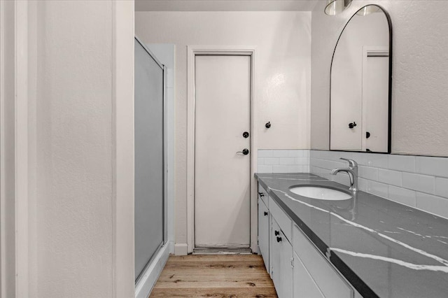 652 E Portals Ave, Fresno, CA 93710 - bathroom featuring decorative backsplash, wood finished floors, vanity, and a stall shower