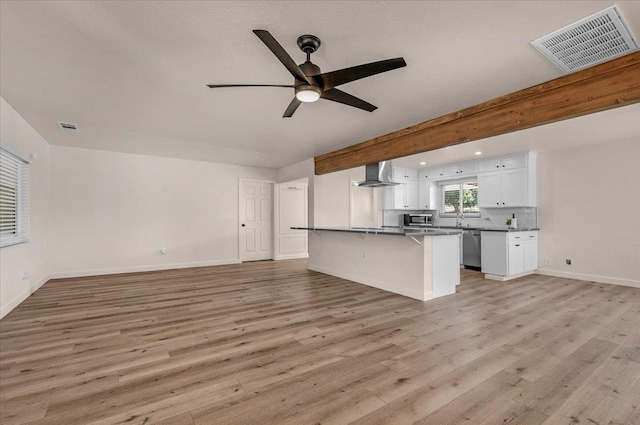 652 E Portals Ave, Fresno, CA 93710 - kitchen featuring wall chimney exhaust hood, open floor plan, a breakfast bar, white cabinets, and a ceiling fan