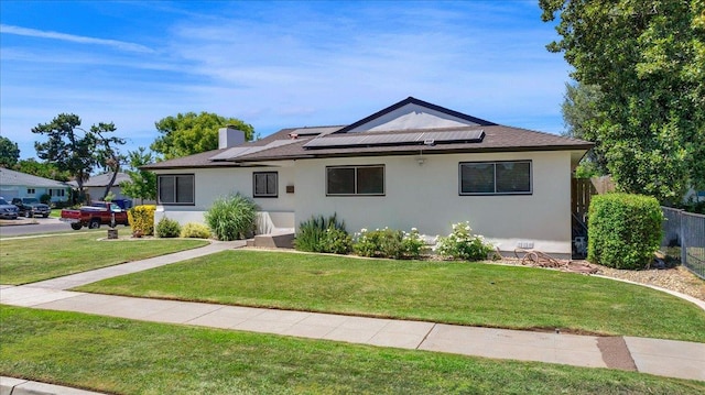 652 E Portals Ave, Fresno, CA 93710 - view of front of home with roof mounted solar panels, stucco siding, and a chimney
